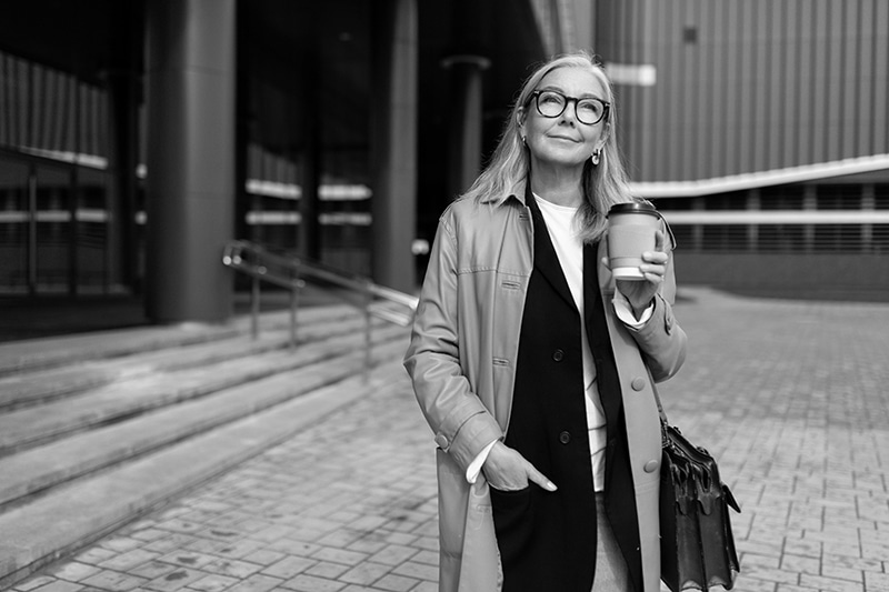 caucasian senior businesswoman with a cup of coffee on the background of the business center