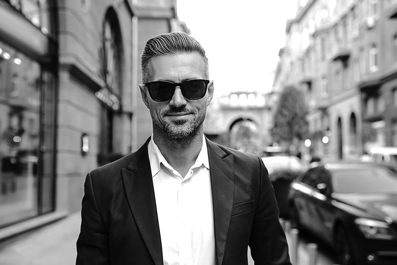 City walk. Man portrait. Handsome man is looking at camera and s